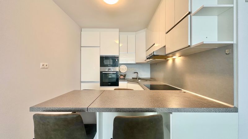 Küche in einer 3-Zimmer-Wohnung mit Eckküche, Kochfeld und eingebauten Geräten.