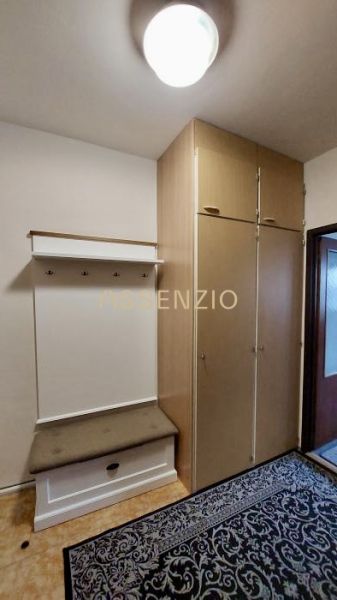Einbauschrank und Garderobenwand mit Bank in einer Einzimmerwohnung.