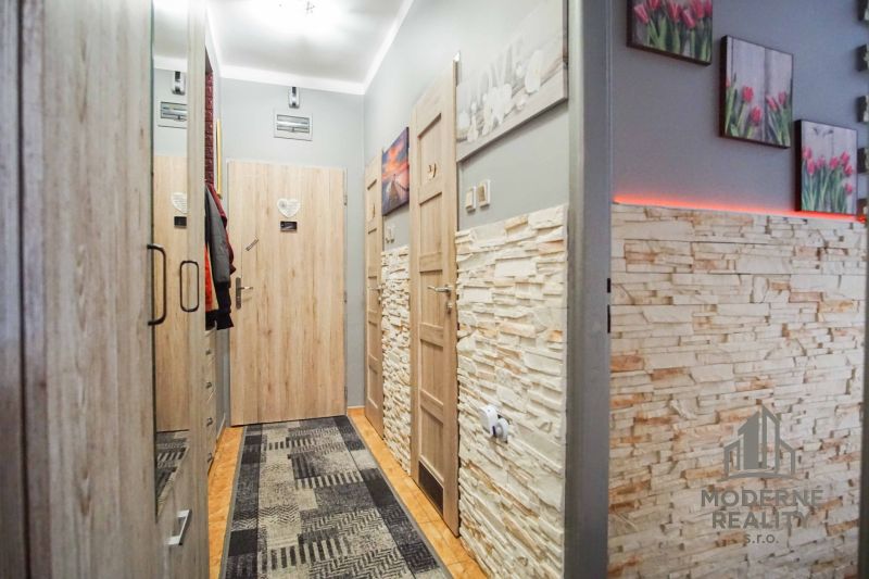 Der Flur in der 2-Zimmer-Wohnung mit Steinwänden und dekorativer Beleuchtung.
