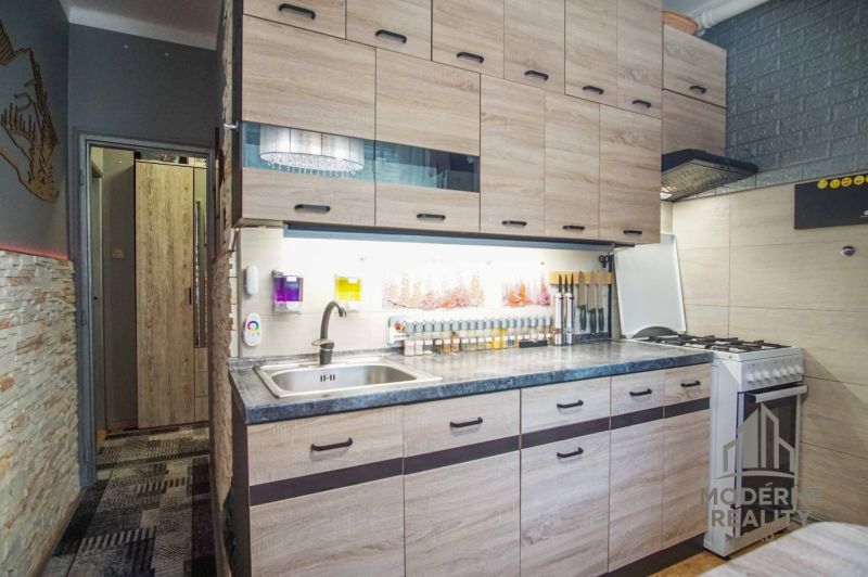Küche in einer 2-Zimmer-Wohnung mit Holzboden und praktischer Küchenzeile.