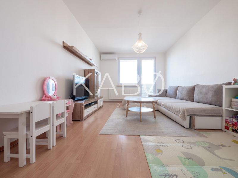Wohnzimmer in einer 2-Zimmer-Wohnung mit Holzboden, Kindertisch und Sofa.