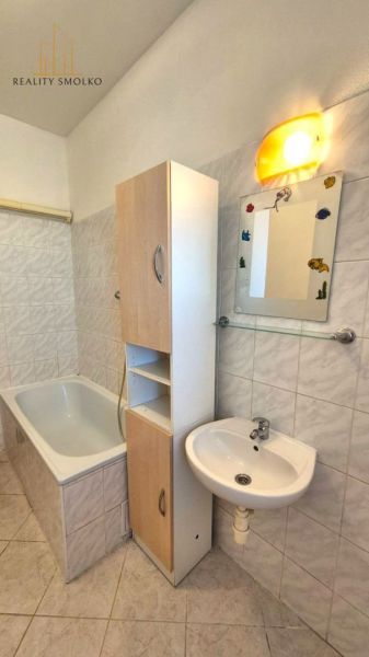 Badezimmer mit Badewanne und Waschbecken in einer Einzimmerwohnung.