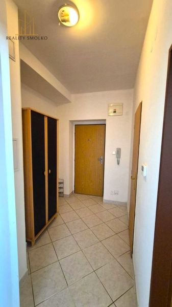 Eingangsflur in einer Einzimmerwohnung mit Fliesenboden und Kleiderschrank.