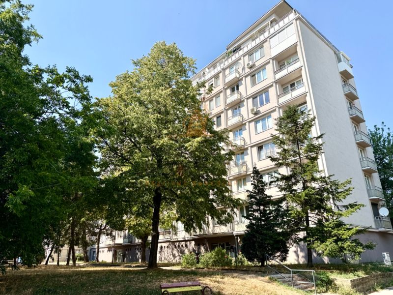Ein Wohnhaus in der Piešťanská Straße in Bratislava - Nové Mesto, umgeben von Grünflächen und einer Bank.