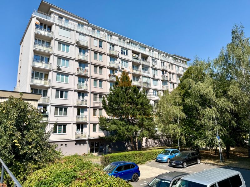Mehrfamilienhaus in der Piešťanská Straße in Bratislava - Nové Mesto, umgeben von Grünflächen und einem Parkplatz.