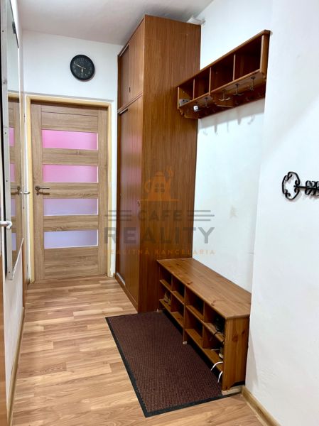 Eingangsflur mit Holzboden, Garderoben und Schrank in einer 2-Zimmer-Wohnung.