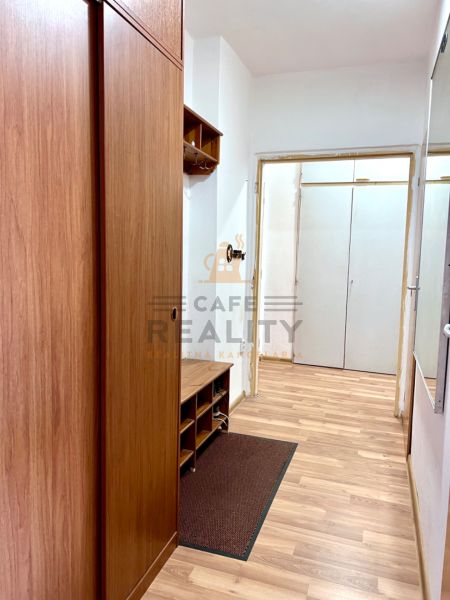 Flur mit Holzboden und Einbauschränken in einer 2-Zimmer-Wohnung.