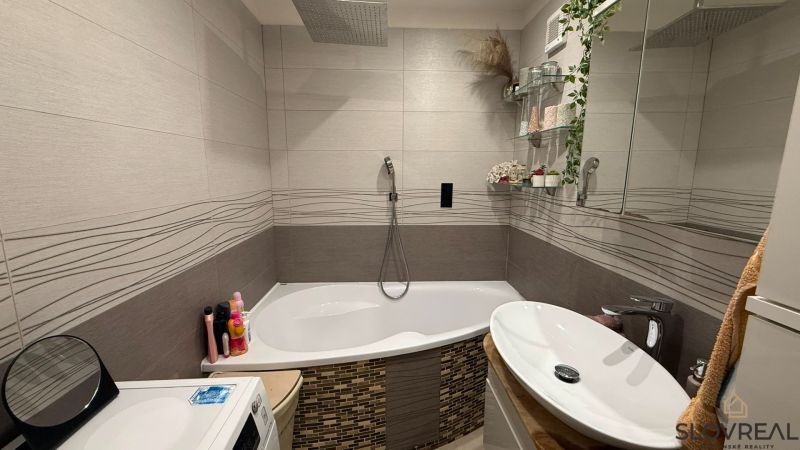 Badezimmer mit Badewanne und dekorativen Fliesen in einer 4-Zimmer-Wohnung.
