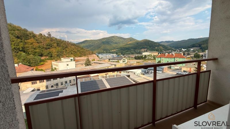 Blick vom Balkon einer 4-Zimmer-Wohnung in Nová Baňa auf die Berge und Gebäude.