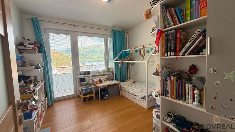 Kinderzimmer mit Bett und Regalen in einer 4-Zimmer-Wohnung, Boden mit Holzdekor.