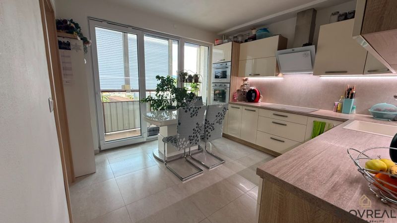 Küche in einer 4-Zimmer-Wohnung mit Esstisch und Zugang zum Balkon.