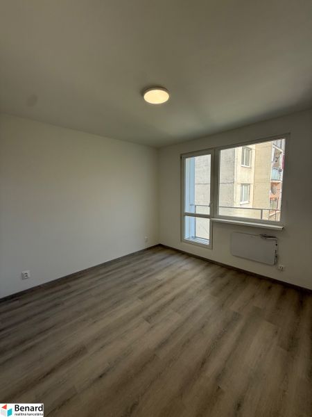 Ein leerer Raum mit Holzboden und weißen Wänden in einer 3-Zimmer-Wohnung.