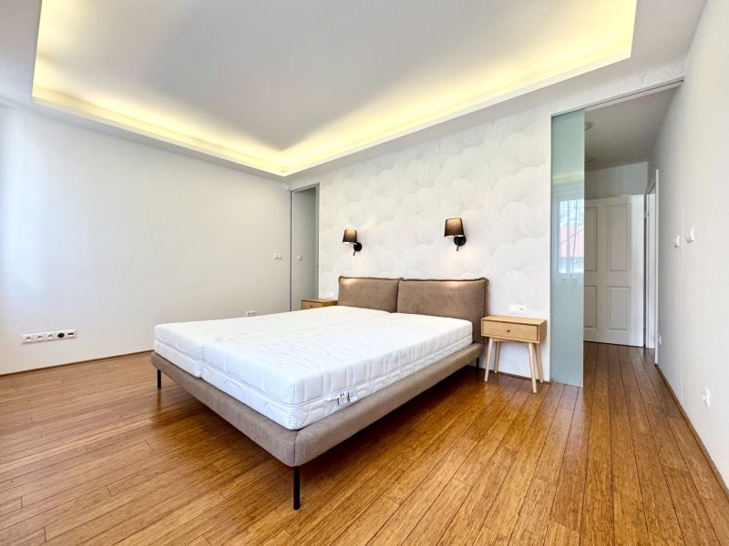 Schlafzimmer in einer 3-Zimmer-Wohnung mit einem Bett und einem Boden in Holzoptik.