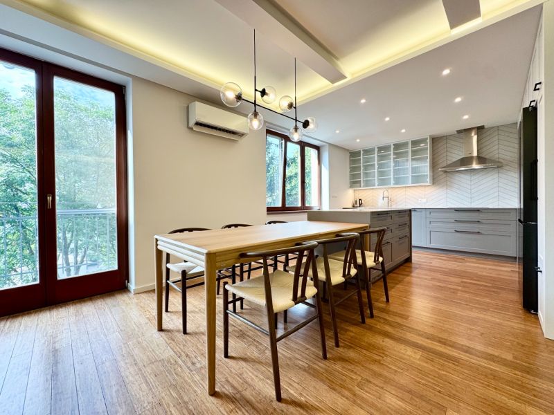 Küche in einer 3-Zimmer-Wohnung, Boden mit Holzdekor, große Fenster, Esstisch.