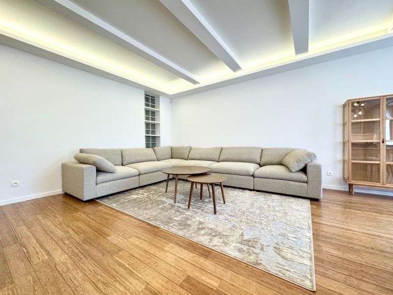Wohnzimmer in einer 3-Zimmer-Wohnung mit einem Sofa, Teppich auf dem Boden mit Holzdekor.