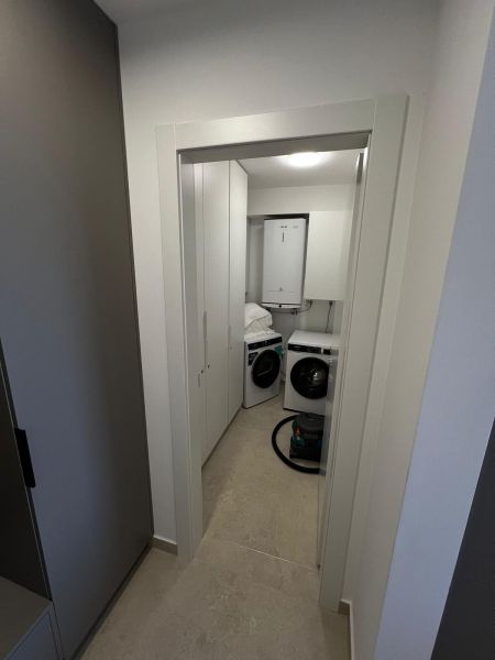 Waschküche mit einer weißen Waschmaschine und einem Trockner in einer 3-Zimmer-Wohnung.