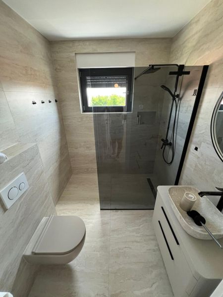 Badezimmer in einer 3-Zimmer-Wohnung mit großer Dusche und hängendem WC.