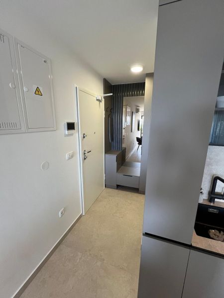 Eingangsflur in einer 3-Zimmer-Wohnung mit minimalistischem Design und Fliesen.
