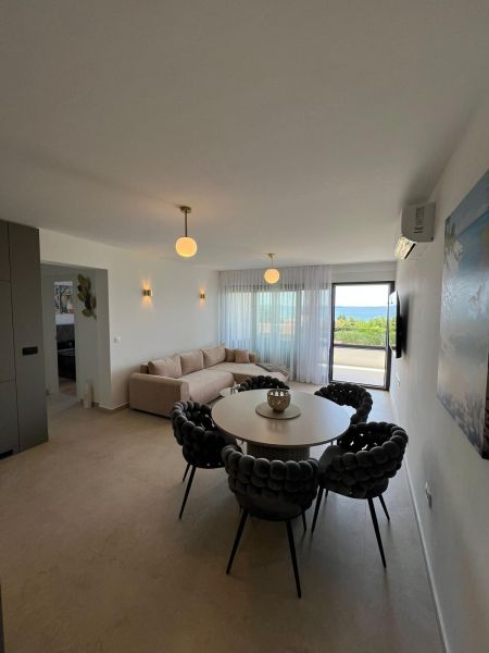Wohnzimmer einer 3-Zimmer-Wohnung mit rundem Tisch, Sofa und Ausblick.