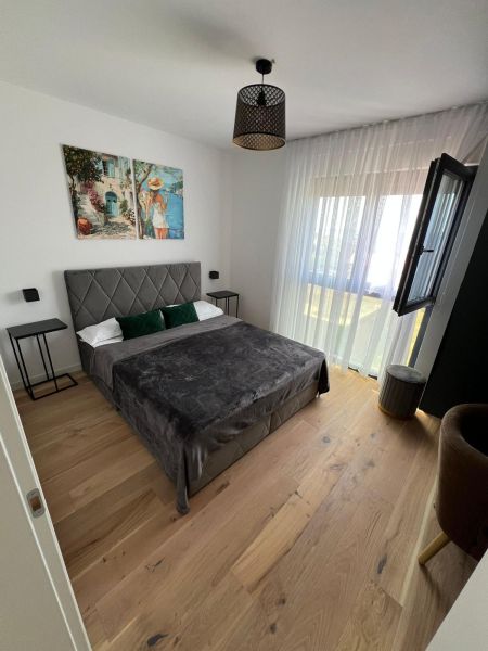 Schlafzimmer mit Bett, Kunstbild und Holzboden in einer 3-Zimmer-Wohnung.