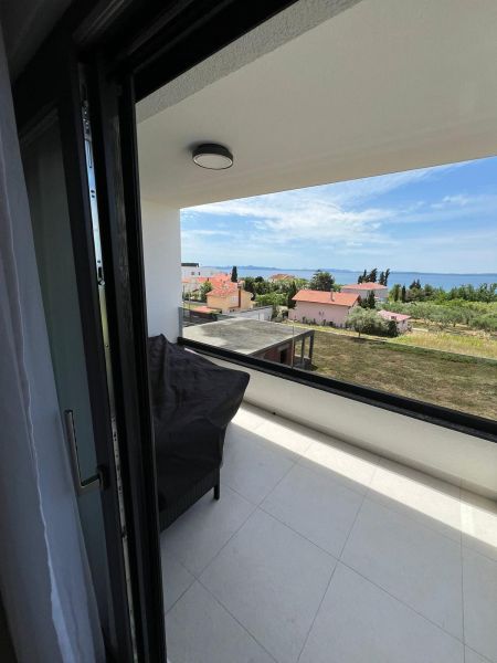 Blick vom Balkon einer 3-Zimmer-Wohnung in Privlaka, mit Blick auf das Meer und die Dächer.