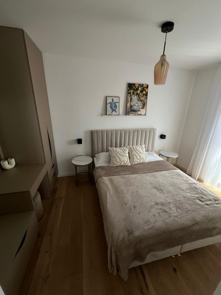 Schlafzimmer in einer 3-Zimmer-Wohnung mit Bett, Schrank und Boden mit Holzdekor.