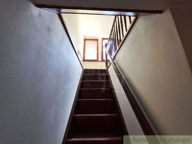 Eine Treppe mit einem hölzernen Geländer, die in den oberen Teil der Geschäftsräume führt.