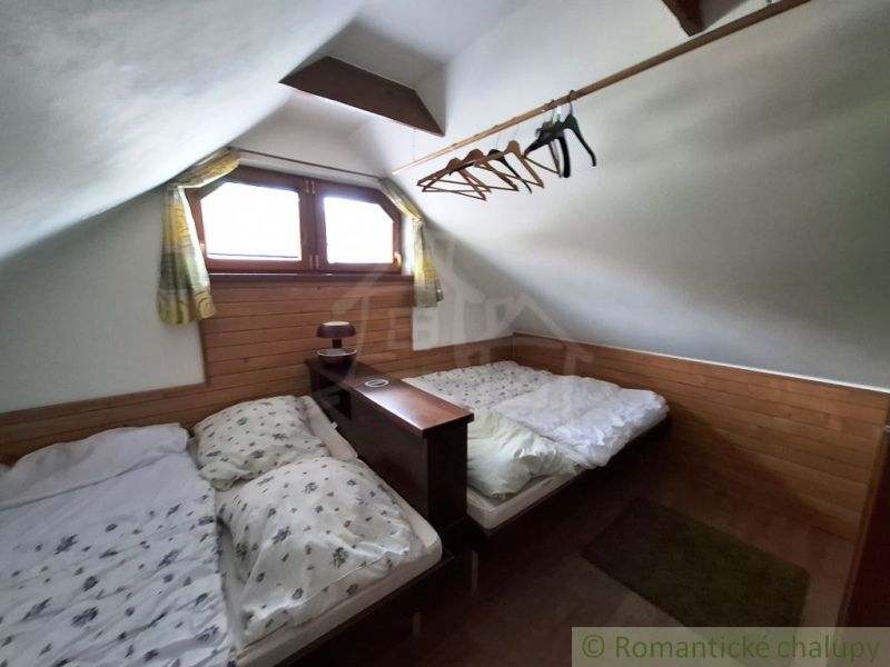 Dachzimmer mit zwei Betten und einem Boden mit Holzdekor in Geschäftsräumen.
