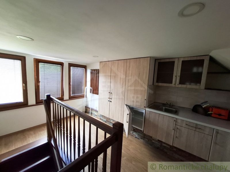 Küche mit Holzboden und Treppe in Geschäftsräumen.