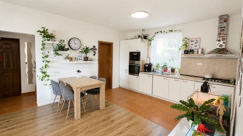 Küche in einer 3-Zimmer-Wohnung mit Pflanzen, Holzboden und Esstisch.