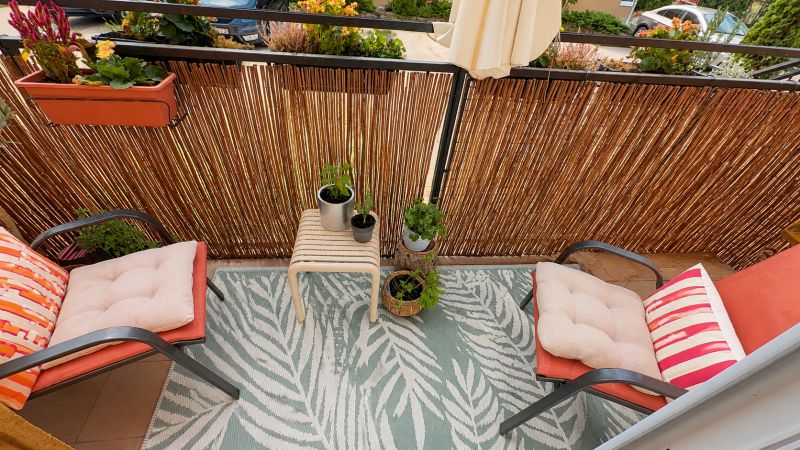 Balkon mit Blumen und Stühlen mit Kissen in einer 3-Zimmer-Wohnung.