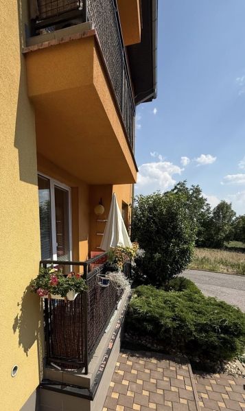 Der Balkon einer 3-Zimmer-Wohnung in Veľký Lapáš mit einem Geländer voller Blumen.