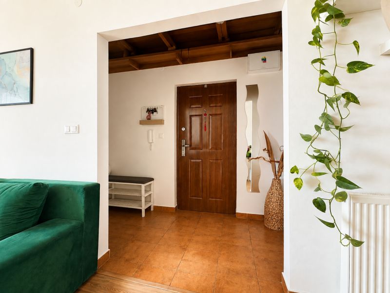 Eingangshalle in einer 3-Zimmer-Wohnung mit grünem Sofa und Dekorationen.