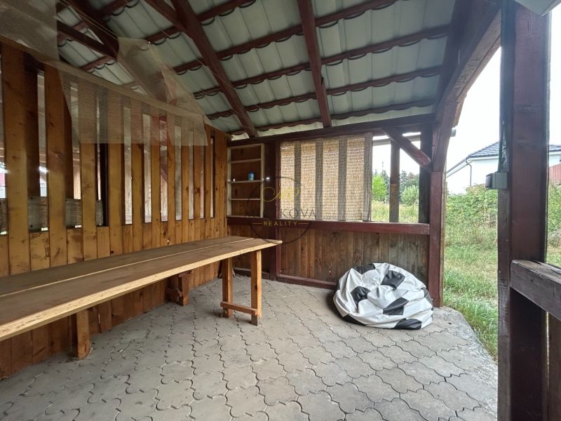 Ein Holzunterstand in Telince und eine 2-Zimmer-Wohnung mit Steinboden im Hintergrund.