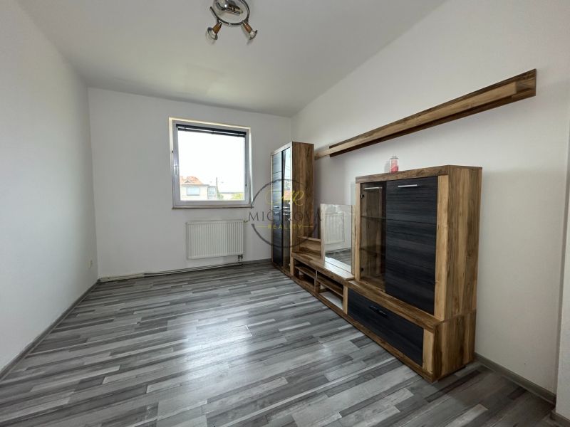 Wohnzimmer in einer 2-Zimmer-Wohnung mit Holzboden und Möbeln.
