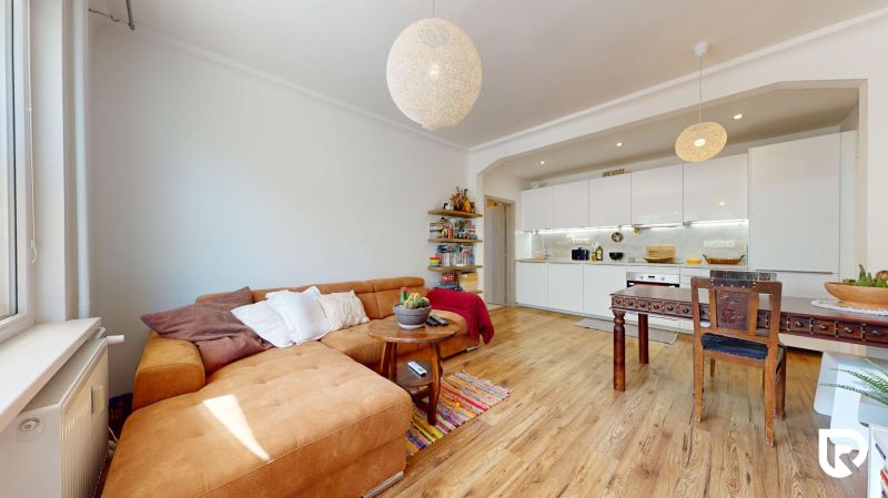 Wohnzimmer mit Küche in einer 3-Zimmer-Wohnung mit Holzboden.