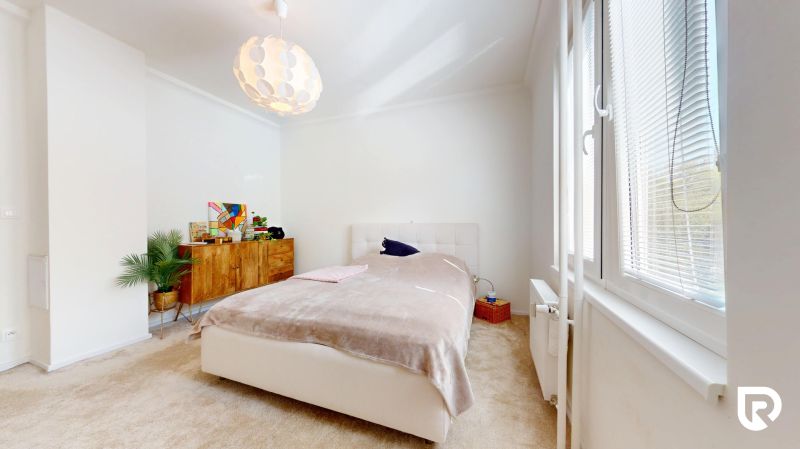 Helles Schlafzimmer mit Bett, Schrank und Fenster in einer 3-Zimmer-Wohnung.