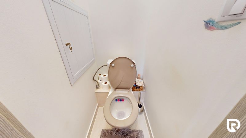 Badezimmer mit Zubehör und Schrank in einer 3-Zimmer-Wohnung.
