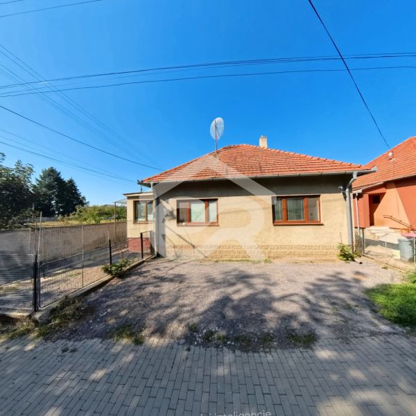 Ein Einfamilienhaus in der Školská-Straße in Tesárske Mlyňany mit einem gepflegten Hof und Zaun.