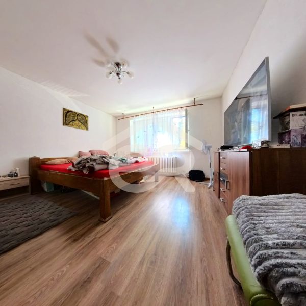 Schlafzimmer im Einfamilienhaus mit Bett, Schrank und Boden mit Holzdekor.