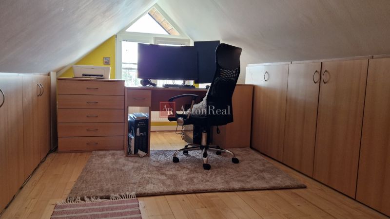 Dachbodenkontor in einer 2-Zimmer-Wohnung mit Holzboden und Schreibtisch.