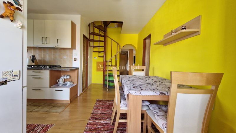 Küche in einer 2-Zimmer-Wohnung mit Holzboden und Wendeltreppe.