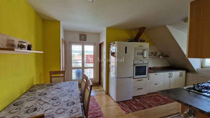 Küche in einer 2-Zimmer-Wohnung mit Holzelementen und gelber Wand.