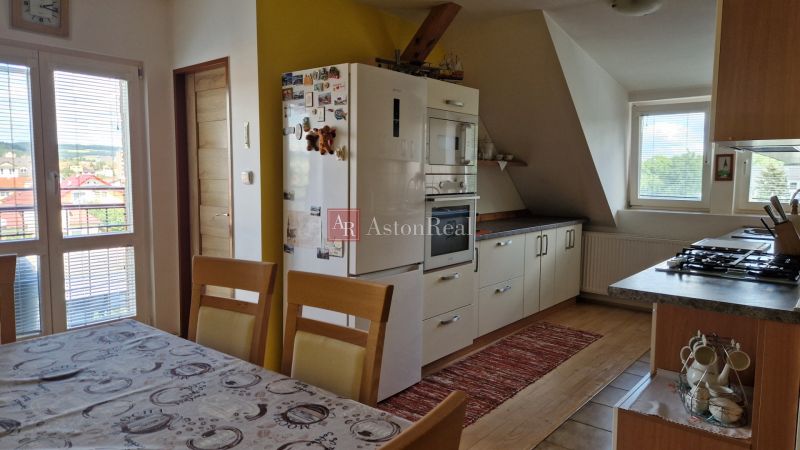 Küche in einer 2-Zimmer-Wohnung mit Holzboden und Esstisch.