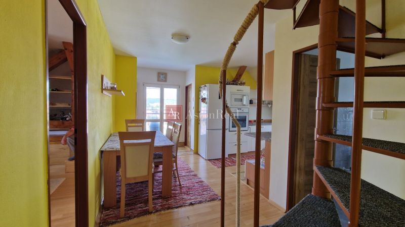Helle Küche mit Esstisch in einer 2-Zimmer-Wohnung mit Holzboden.