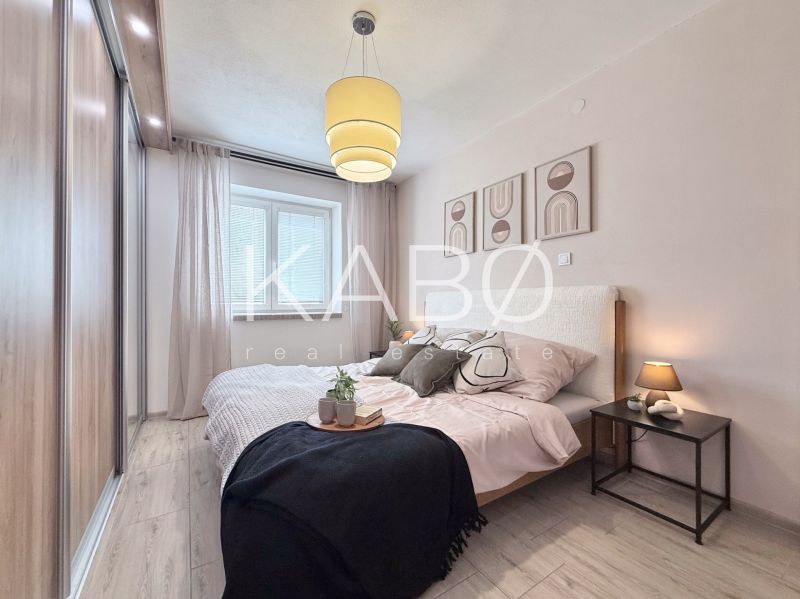 Schlafzimmer in einer 2-Zimmer-Wohnung mit Holzboden und Wanddekoration.