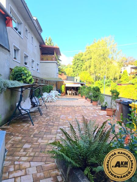 Ein Einfamilienhaus in Zvolen mit einem gepflasterten Hof und einem Gartenpavillon.