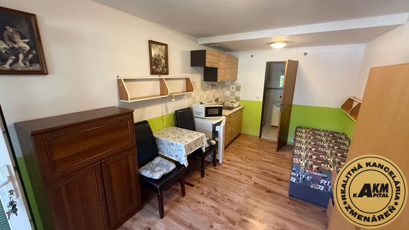 Innenraum mit Küchenzeile, Tisch und Holzboden in einem Einfamilienhaus.