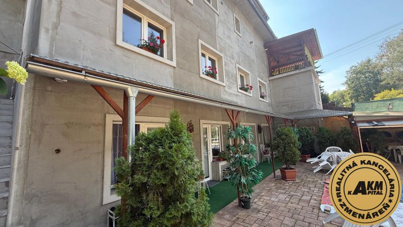 Ein Einfamilienhaus in Zvolen mit grünen Pflanzen auf der Terrasse und Fenstern mit Blumen.