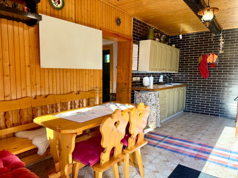 Holzinterieur der Küche mit Esstisch und Stühlen in einem Einfamilienhaus.